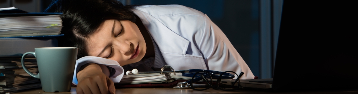 Un'operatrice sanitaria dorme piegata su un tavolo