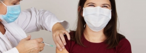 La foto mostra un'operatrice sanitaria mentre effettua la vaccinazione ad una paziente